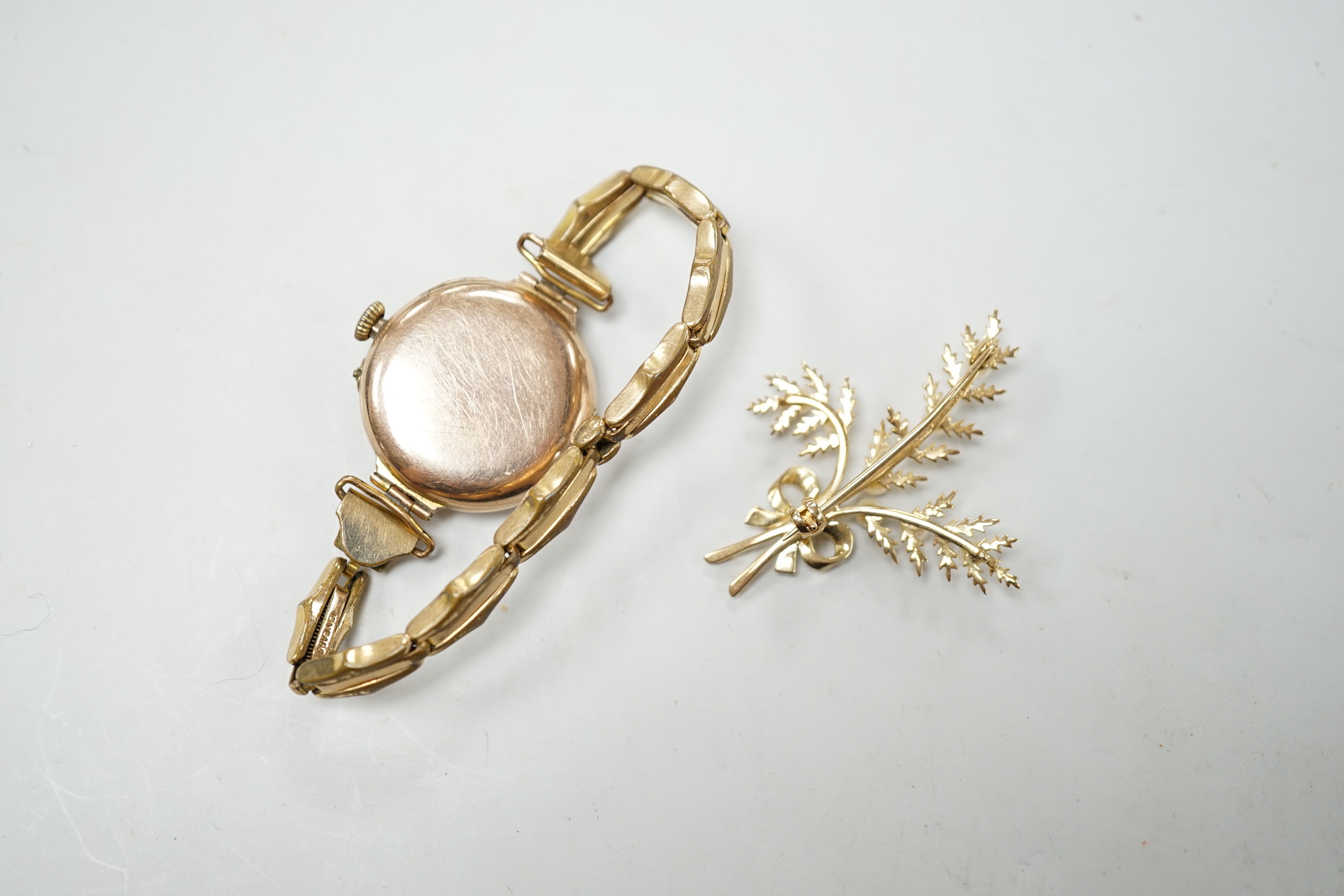 A lady's early 20th century 9ct gold, manual wind wrist watch, on a gold plated strap, together with a modern 9ct gold and seed pearl floral spray brooch.